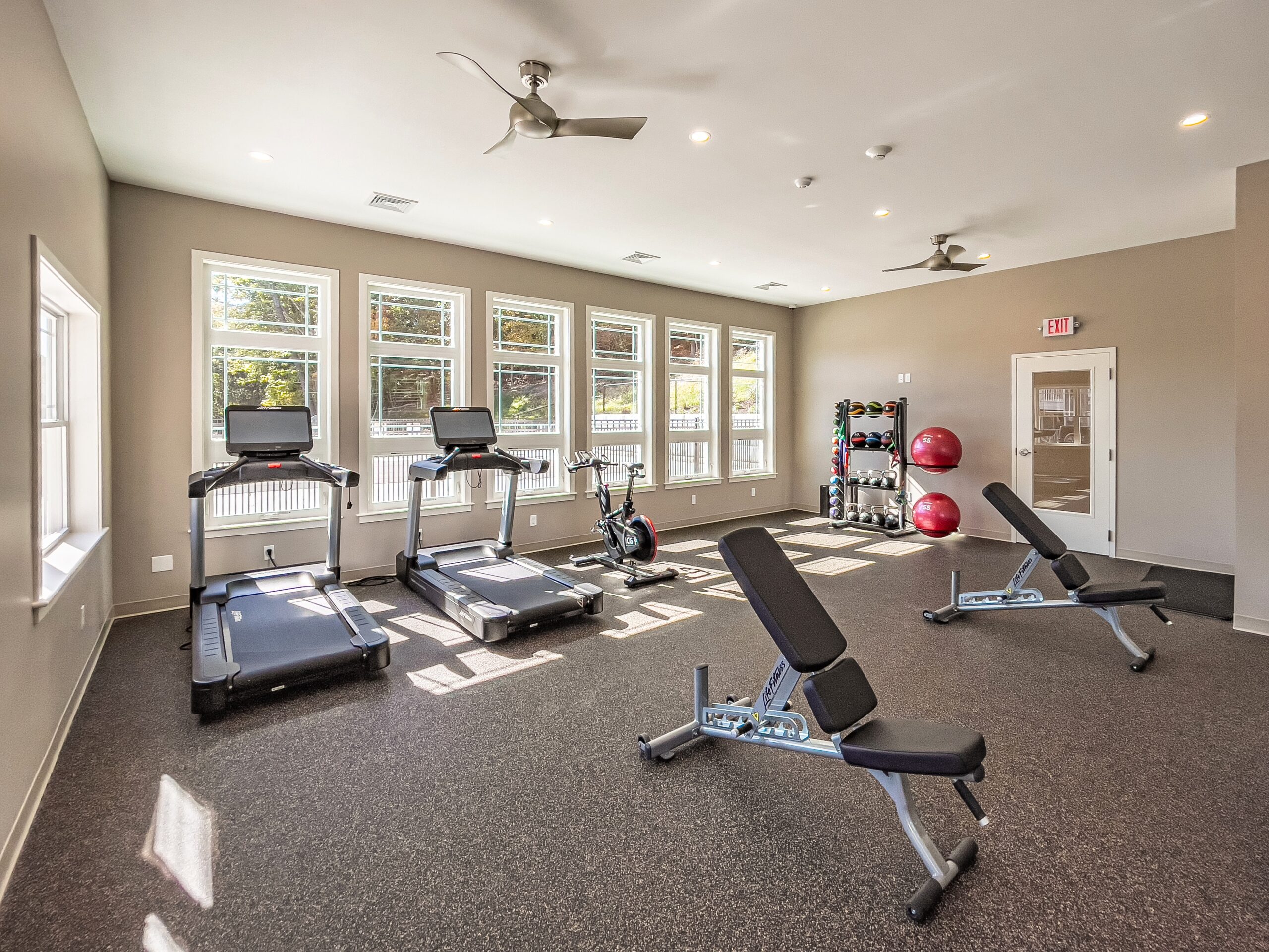 exercise room with treadmills, benches and lots of natural light