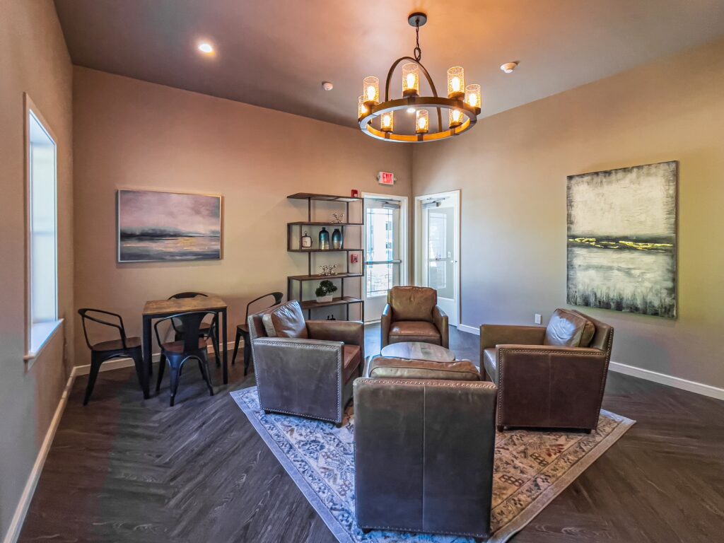 Clubroom with leather chairs, bookshelf and card table with chairs